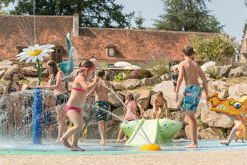 [Translate to Néerlandais:] des familles qui jouent dans l'espace aquatique d'un camping de luxe